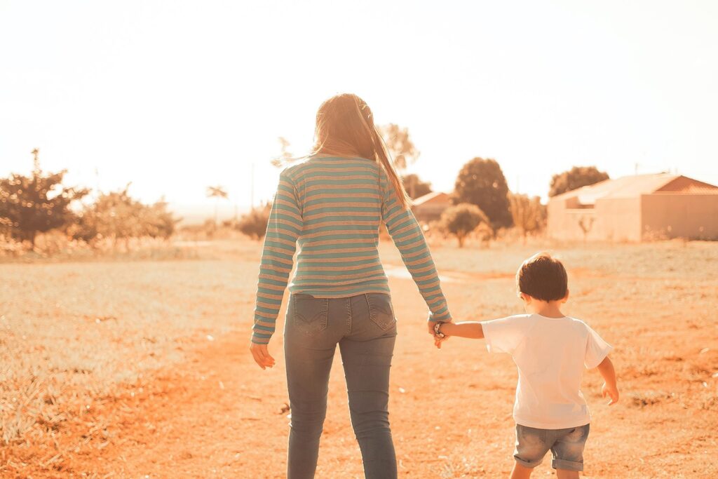 Mother and son walking while holding hands