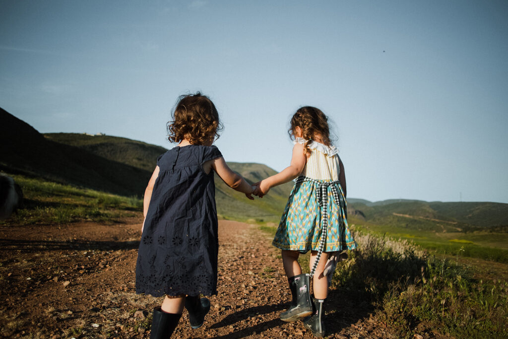two little girls walking along a trail holding hands